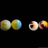 Four marbles side by side on black background