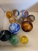 Group of eleven assorted glass marbles showing sizes and colors