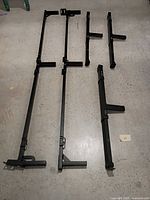 Disassembled adjustable metal bed frame parts laid out on floor
