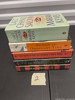 Stack of five paperback novels showing spines and titles