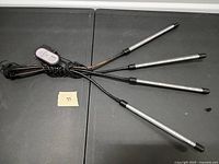 Four-arm LED grow light coiled on table showing goosenecks, LED bars, and remote