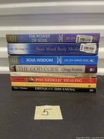 Stack of eight paperback books showing all spines