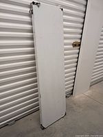 Full view of stainless steel shelf leaning against wall