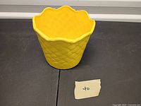 Full view of yellow ceramic vase with diamond quilted pattern and scalloped rim