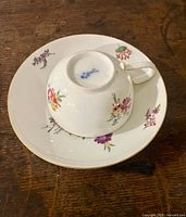 Cup inverted on saucer showing Meissen blue crossed swords mark and floral design
