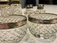 Cut-crystal salt cellars, hallmarked sterling rims visible
