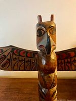 Close view of thunderbird head and wings showing carved and painted detail