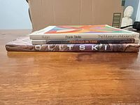 Side view showing spines of the three books Frank Stella, Pressed In Time, Olitski