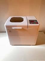 Front and top view of white Kitchen Gourmet breadmaker with viewing window