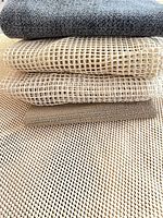 Stack of six folded carpet under-pads showing mesh and felt textures