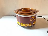 Front view of Sunbeam Mini-Crock with yellow daisy design and power cord