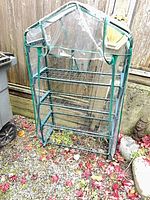 Full view of mini greenhouse showing frame, shelves and cover