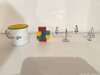Full lot view: mug, wooden puzzle, two metal figures
