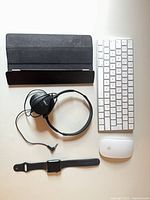 Group shot showing all five items: keyboard, mouse, watch, iPad cover, headphones
