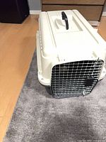 Front view of pet carrier showing metal door and carry handle