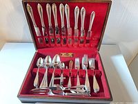 Flatware arranged in red-lined wooden chest
