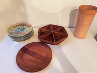 Stack of BIA cheese plates, wooden plate, wicker basket, terracotta wine cooler