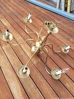 Brass chandelier with six arms and wiring visible