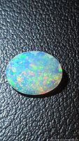 Top view of oval faceted opal showing play of colour