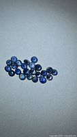 Cluster of small round blue sapphires on neutral background
