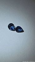 Both pear-cut sapphires side by side on neutral background