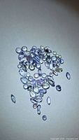 Pile of assorted faceted tanzanite stones on white background