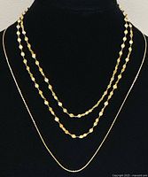 Two necklaces displayed on bust showing design and layering