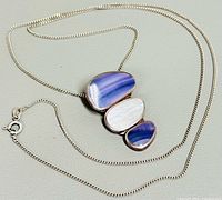 Full view of silver chain and three-stone pendant