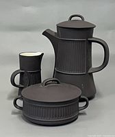 Front view of coffee pot, creamer, sugar bowl with lids