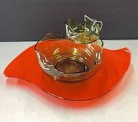 overview of orange serving bowl with green dip bowl attached by metal clip