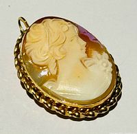 Front view of cameo showing carved female profile and gold-tone frame