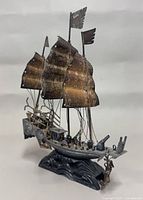 front angled view showing sails, cannons, anchor, wave base