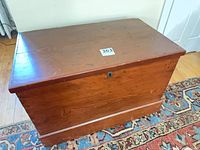 Top view of refinished wooden trunk showing flat lid and lock escutcheon