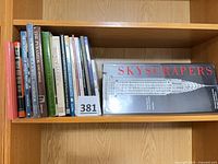 Shelf of assorted books with visible spines and large 'Skyscrapers' hardcover