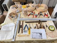Overview of coils of cane, tools, clamps and measuring devices on table