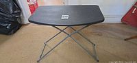 Table standing folded out showing plastic top and metal legs