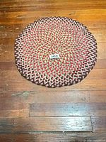 Full view of round braided rug on wooden floor