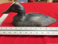 Left side view of cast iron duck with rulers showing scale