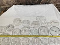 All 19 clear glass lids laid out with measuring tape