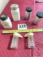 All six shakers arranged with measuring tape