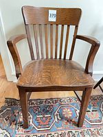 Front view of oak armchair with slat back and arms