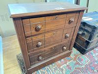 Front view showing three drawers with round knobs and lock escutcheons