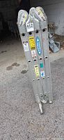 Collapsed Werner aluminum articulating ladder upright