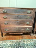 Front view showing four drawers, metal pulls, keyholes