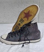 Side view of left shoe showing canvas upper, turquoise eyelets, rubber sole and star pattern tread