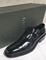Lateral view of single shoe with Gucci box