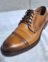Single shoe angled view showing leather, brogue detail, and condition