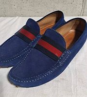 Pair of blue suede Gucci loafers angled view