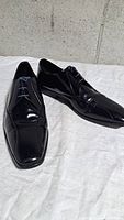 Both shoes angled view showing glossy patent leather