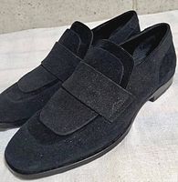 Oblique view of both loafers showing uppers, strap and toe